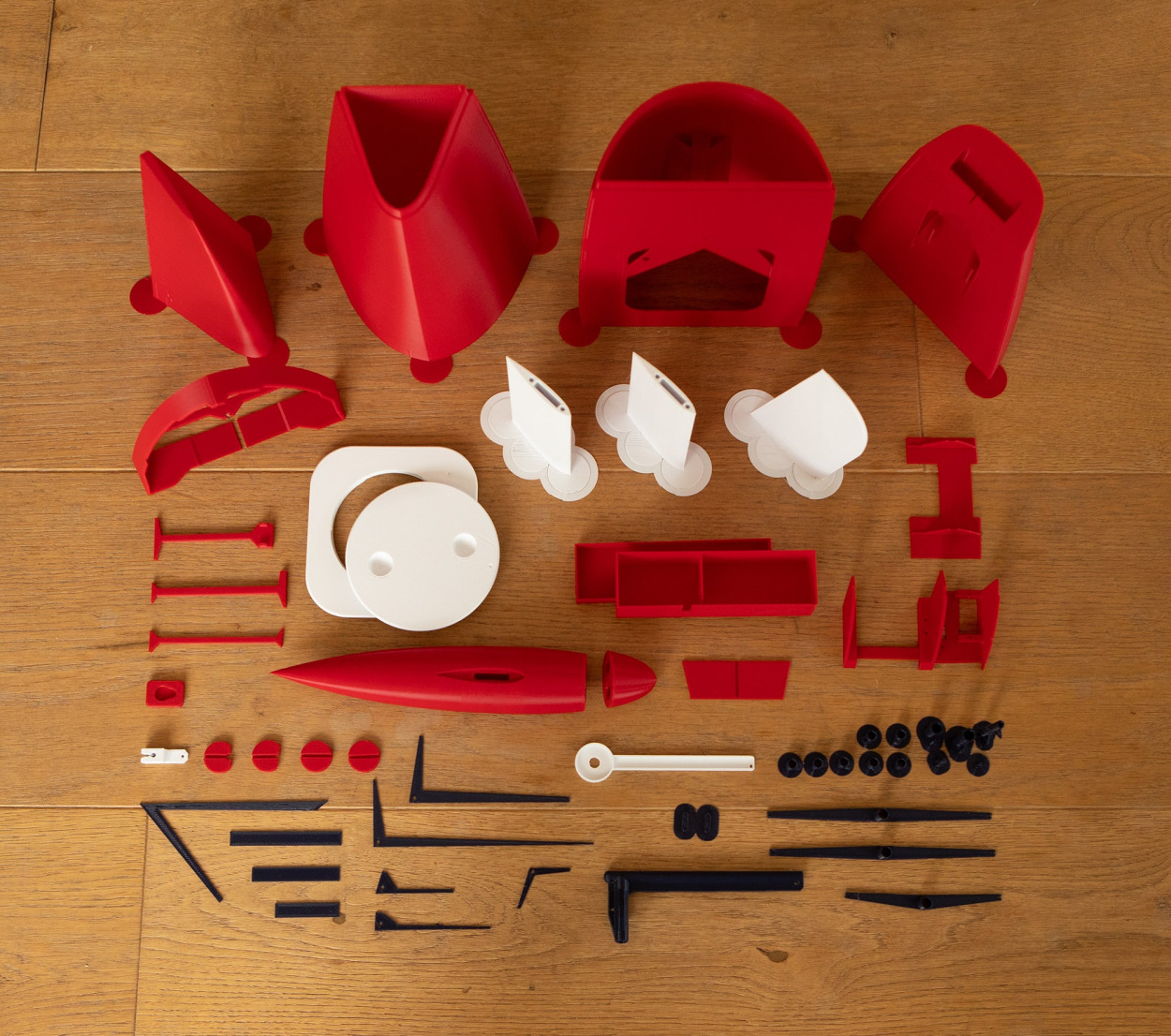 Racing Sparrow RS760 - 3D printed parts layed out on a wooden floor for display