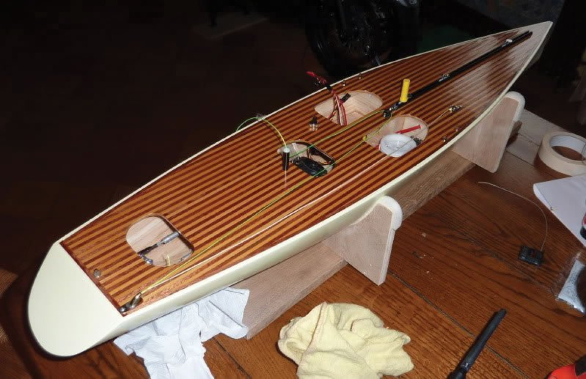 ギャリー・エンジェルのレーシング・スパロウの1メートルモデルヨット。明るいシダーウッドと暗いシダーウッドのストリップが交互に配置された美しいデッキを展示しています。見た目が素晴らしいモデルです。