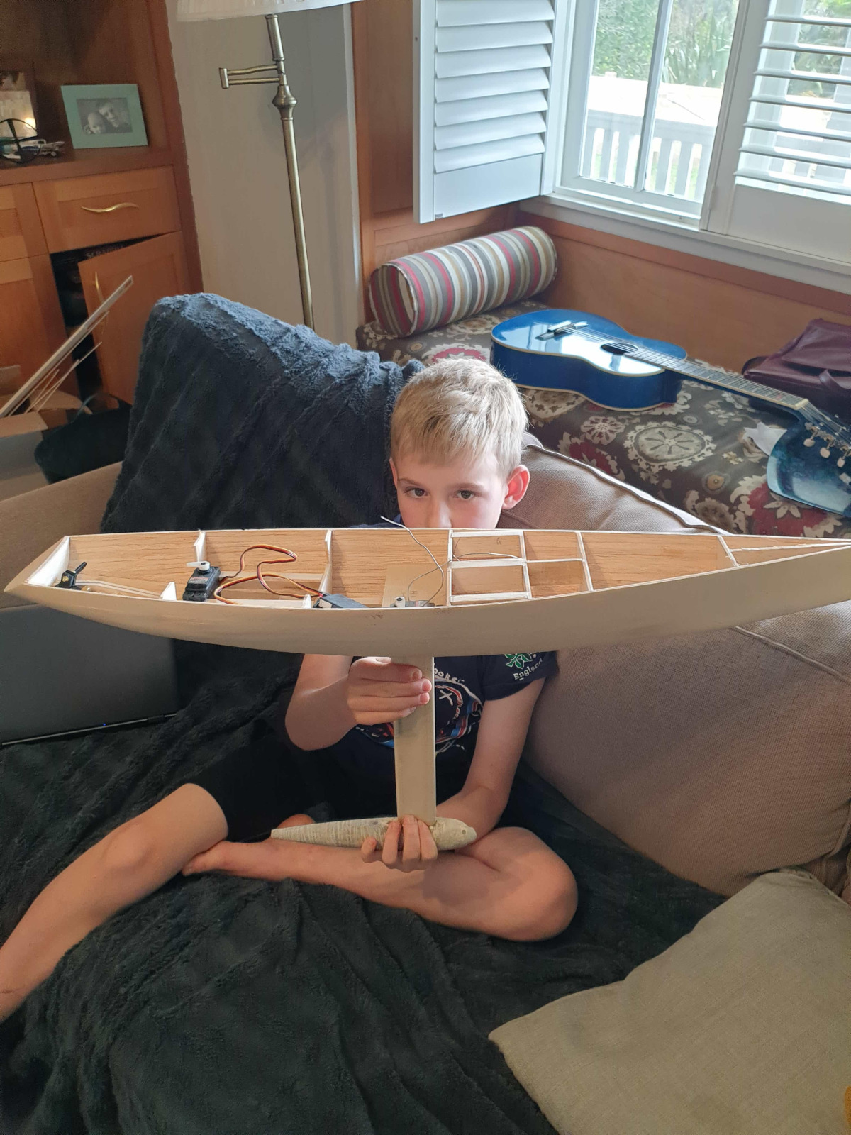 Andy Saunders and son holding a model yacht, balsa construction, Location: New Zealand