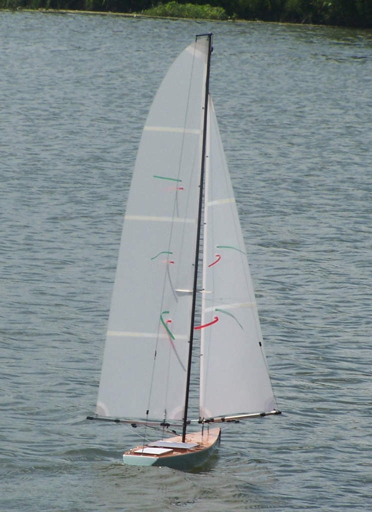 A racing sparrow sailing downwind on a flat water lake, sails winged either side, Location: USA